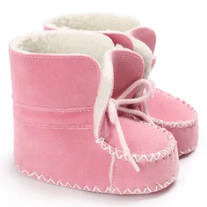 Dettaglio di stivaletti per neonati rosa con fodera in pelliccia sintetica e cuciture decorative