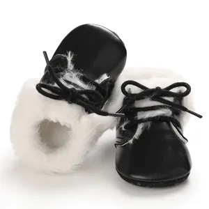 Close-up detail of black baby boots featuring soft soles and fluffy white faux fur lining