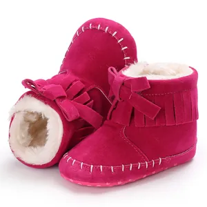 Detail view of infant fringe moccasin boots with soft fur lining in vibrant magenta.