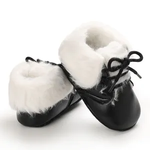 Detailed view of black baby boots featuring soft white faux fur lining and black laces.