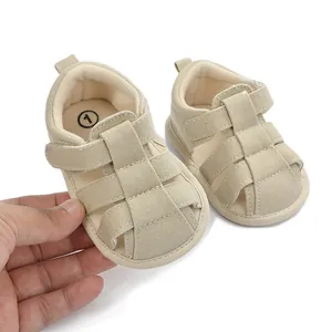 Primer plano detallado de sandalias beige transpirables de lona para bebé con tira de velcro