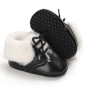 Detail view of black infant fur boots with white faux fur lining and non-slip sole.