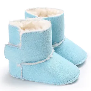 Vista detallada de botas de invierno para bebé azul claro con forro de piel sintética blanca.