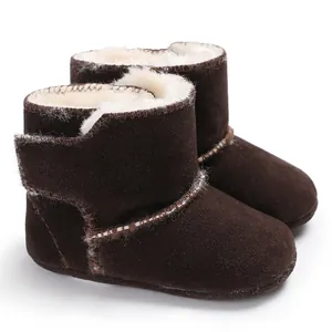 Detailweergave van donkerbruine baby-suède laarzen met warme witte fleece voering