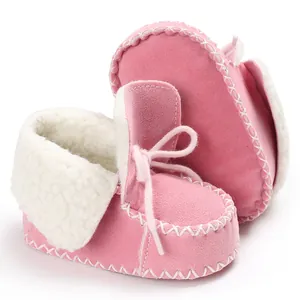 Detailed close-up of pink baby boots with soft fleece lining and cross-stitching craft