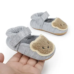 Detailaufnahme von Baby-Lernlaufschuhen mit süßem Plüsch-Bär-Design und weichem Stoff