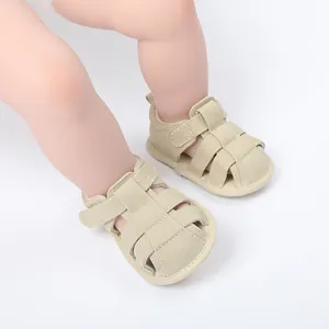 Primer plano de sandalias beige transpirables para bebés que aprenden a caminar en interiores