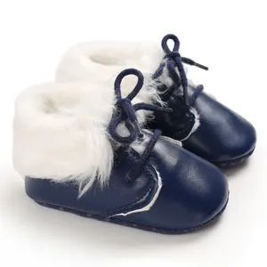 Detail shot of navy blue infant boots with soft soles and thick white faux fur trim