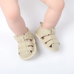 Primer plano de sandalias de marcha para bebé en lona beige transpirable en pies