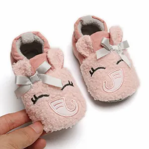 Detailed macro view of soft pink plush baby shoes with cute elephant face and grey bow