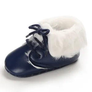 Close-up detail of navy blue baby infant boots with white faux fur lining and laces.