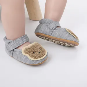 Graue Baby-Lauflernschuhe mit süßem Plüschbären-Design und rutschfester Sohle im Detail.