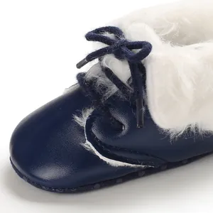Close-up of navy blue baby fleece boots showing white faux fur lining and laces