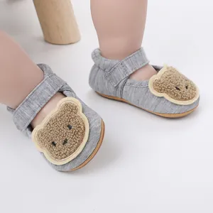 Nahaufnahme grauer Baby-Lernlaufschuhe mit 3D-Bären-Patch und praktischem Klettband