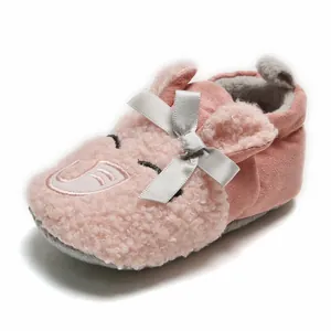 Close-up of pink plush baby winter slipper with cute elephant face and bow detail