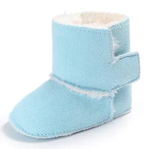 Primer plano de botas de invierno azules para bebé con forro de pelo sintético y velcro