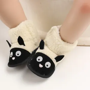 Gros plan d'adorables bottes de neige en polaire pour bébé avec motif de mouton et texture douce