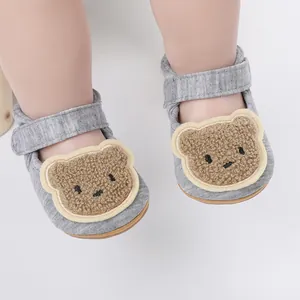 Detailed macro view of soft grey baby walking shoes with cute fuzzy bear patch