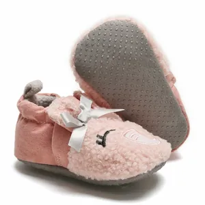 Detailed view of pink fuzzy baby shoes showing non-slip sole and cartoon elephant