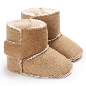 Primer plano de botas de invierno para bebé con suave forro de piel sintética y velcro.