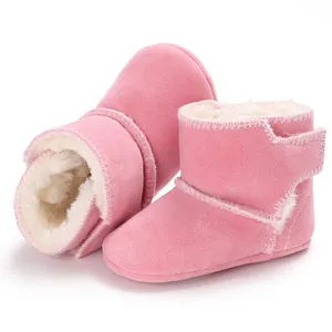 Detail van roze babylaarsjes met een zachte voering van imitatiebont en suède look.