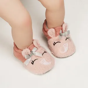 Close-up of pink plush baby winter shoes with cartoon elephant face and silver bow