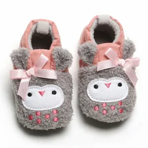 Detailed macro view of pink and grey owl-patterned baby winter booties with soft soles