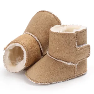 Detalle de botas de invierno marrón para bebé con forro de felpa suave y costuras blancas