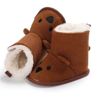 Detailaufnahme von kuscheligen braunen Strick-Babystiefeln mit weichem weißem Fleece-Futter