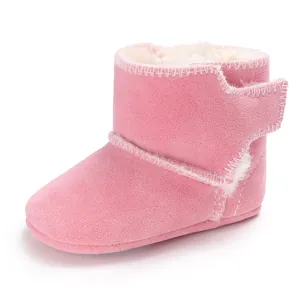 Zijaanzicht van roze suède babylaarzen met warme voering van imitatiebont en zachte zool.