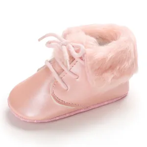 Soft pink baby booties with cozy faux fur trim and lace-up design for toddlers.