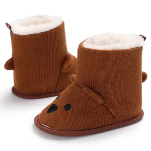Detailaufnahme brauner Baby-Strickstiefel mit Teddygesicht und flauschigem Kunstfellfutter.