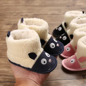 Gros plan de bottes d'hiver pour bébé avec motif de mouton et doublure peluche