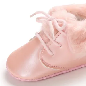 Close-up of pink baby boots with soft faux fur lining and functional lace-up detail