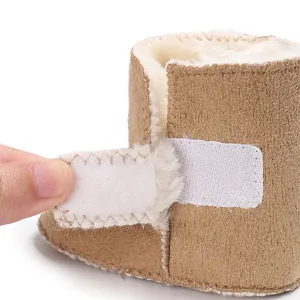 Primer plano de botas de invierno para bebé con forro de piel sintética y velcro.