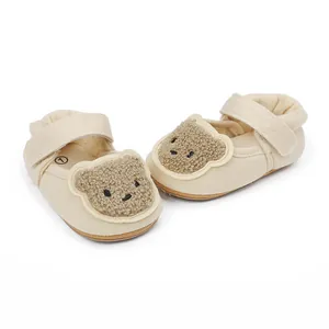 Detaillierte Ansicht beigefarbener Babyschuhe mit einem süßen Plüschbären-Dekor