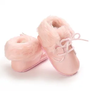 Detailed view of baby faux fur boots in soft pink with lace-up design and plush lining