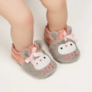 Close-up of cute owl baby slippers with plush texture and pink bows