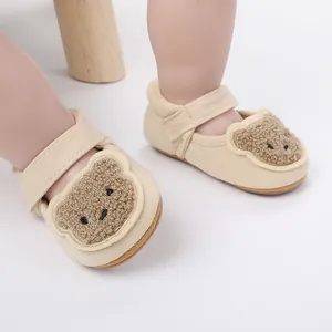 Detailansicht von beigen Babylauflernschuhen mit Bären-Design und Klettverschluss.