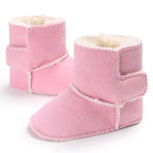 Primer plano de botas de invierno rosas para bebé con forro polar y velcro