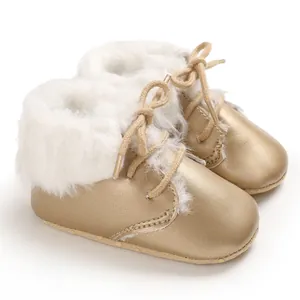 Close-up of golden baby fur boots with soft soles and warm white faux fur lining