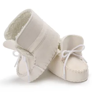 Dettaglio di stivaletti neonato beige caldi con fodera in pile e fiocco decorativo