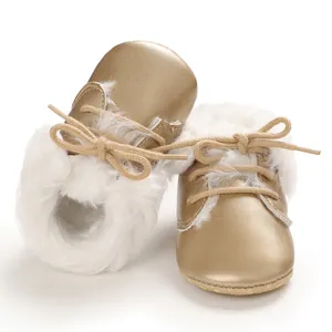 Detailed shot of baby gold fur boots with soft soles and white plush faux fur lining