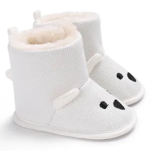 Detailansicht der weißen Strick-Babystiefel mit Plüschfutter und süßem Bärengesicht.