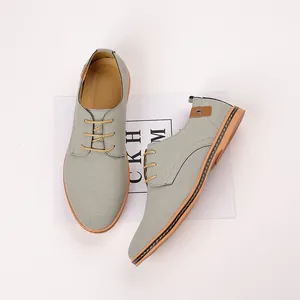 Close-up view of grey men's casual suede shoes featuring stylish yellow laces and tan soles