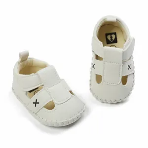 White infant walking sandals with heart logo insole and cross embroidery details