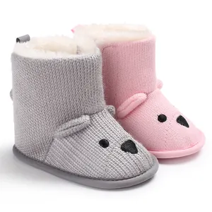 Detailaufnahme von süßen gestrickten Baby-Boots mit Bärenmotiv und warmem Fleecefutter