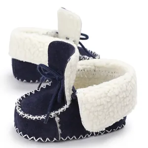 Primo piano di scarpine invernali blu navy per neonati con dettagli in pile.