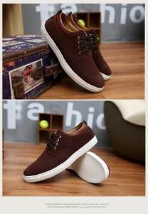 Vista dettagliata di sneaker da uomo in pelle scamosciata marrone con suole bianche.