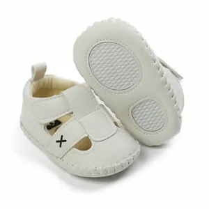 Detailed macro view of white infant walking sandals showing anti-slip diamond sole.